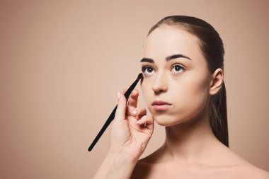 Kadın makeupon bej renkli arka plan uygulamak