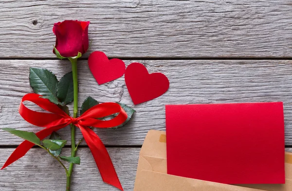 Fundo dos namorados, vermelho rosa flor, corações de papel artesanal, cartão de saudação no envelope em madeira rústica — Fotografia de Stock