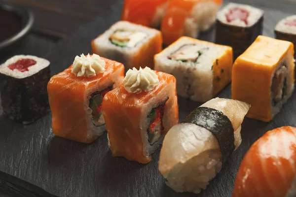 Conjunto de sushi em fundo preto de madeira, pov — Fotografia de Stock