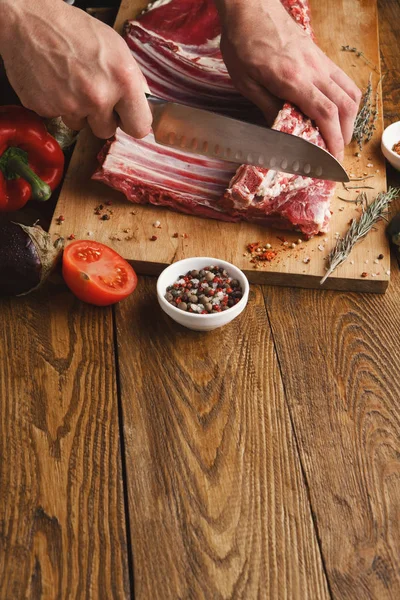Stojan na řezání šéfkuchař jehněčí na dřevěné desce v kuchyni — Stock fotografie