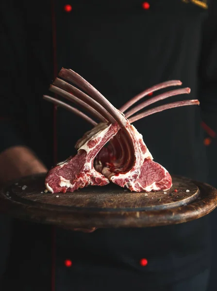 Raw cut rack of lamb on wooden board