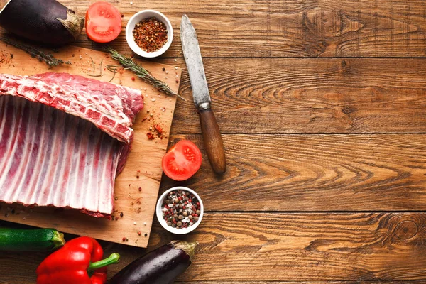 Raw rack of lamb on wooden board — Stock Photo, Image