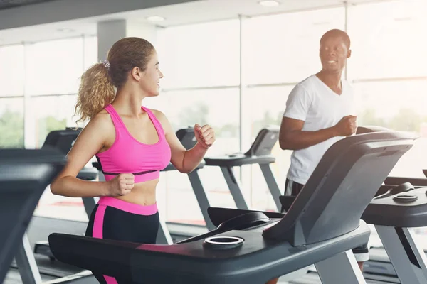 Hombre y mujer, pareja en gimnasio en cintas de correr — Foto de Stock