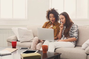 Kredi kartı ve dizüstü bilgisayar ile iki kadın online