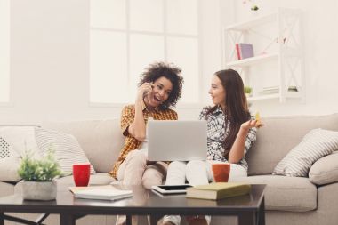 Kredi kartı ve dizüstü bilgisayar ile iki kadın online