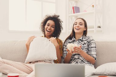 Evde film izlerken gülümseyen genç kadın