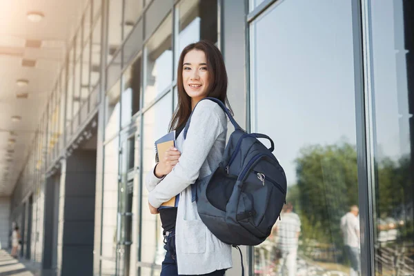 Student girl with books on university background — Stock Photo, Image