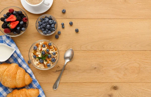 Continental breakfast with croissants and berries on natural wood — Stock Photo, Image