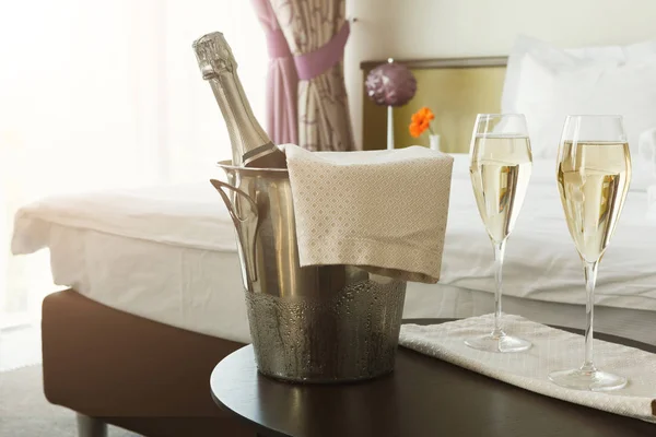 Dois copos e garrafa de champanhe no hotel — Fotografia de Stock