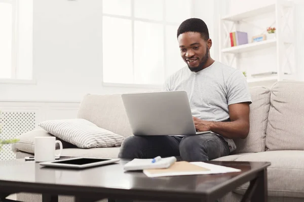 Молодий чоловік вдома обміну повідомленнями онлайн на ноутбуці — стокове фото