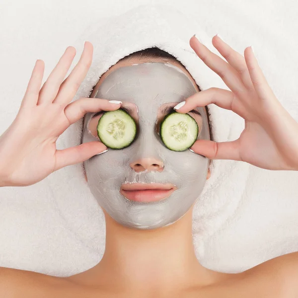 Belle fille avec masque d'argile appliquée sur fond blanc — Photo