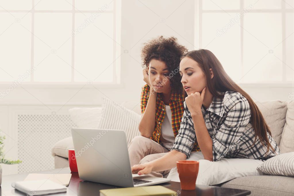 Two beautiful women using laptop at home