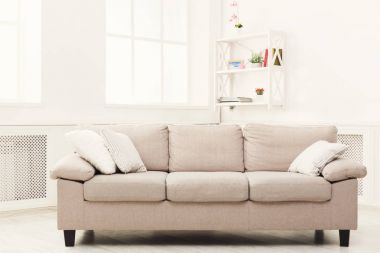Beige couch on white window background clipart