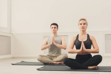 Genç çift padmasana içinde oturan yoga uygulamak