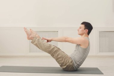 Genç adam pratik Yoga ile jimnastik minderi