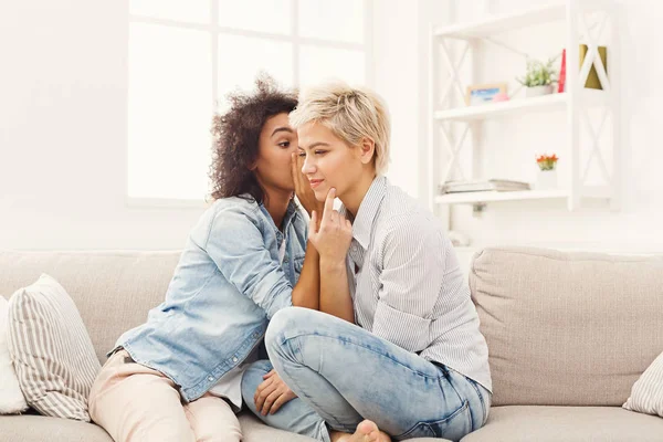 Giovane donna dicendo al suo amico alcuni segreti — Foto Stock