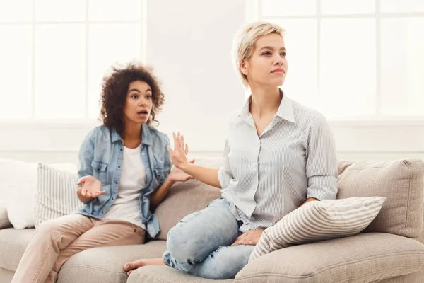 Dos amigas sentadas en un sofá discutiendo —  Fotos de Stock