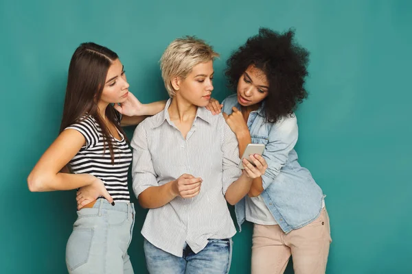 Tre kvinnliga vänner som använder smartphones — Stockfoto