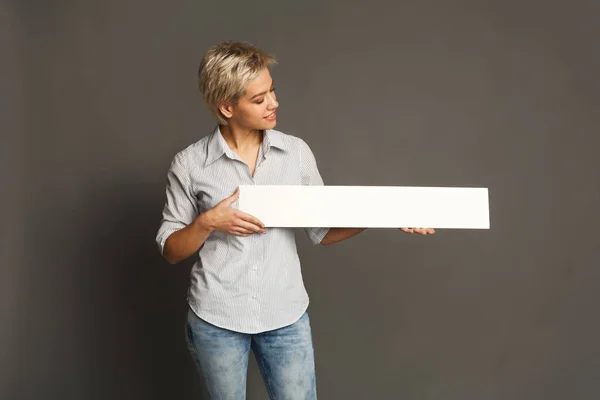 Молода жінка тримає порожній білий банер — стокове фото