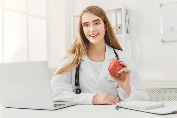 Lachende voedingsdeskundige vrouw met apple op kantoor — Stockfoto