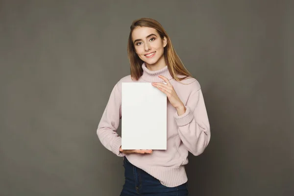 Молода усміхнена жінка з чистим білим папером — стокове фото