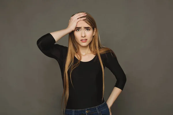 Förvirrad ung kvinna, dunka handen på huvudet — Stockfoto