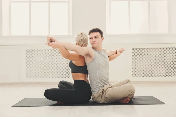 Unga par praktisera yoga tillsammans i studion — Stockfoto