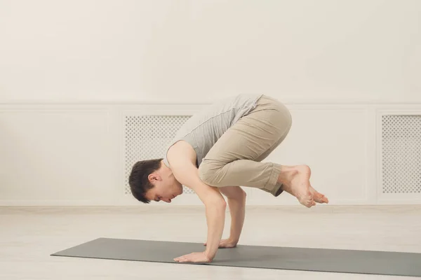 Ayakta Bakasana egzersiz genç adam — Stok fotoğraf