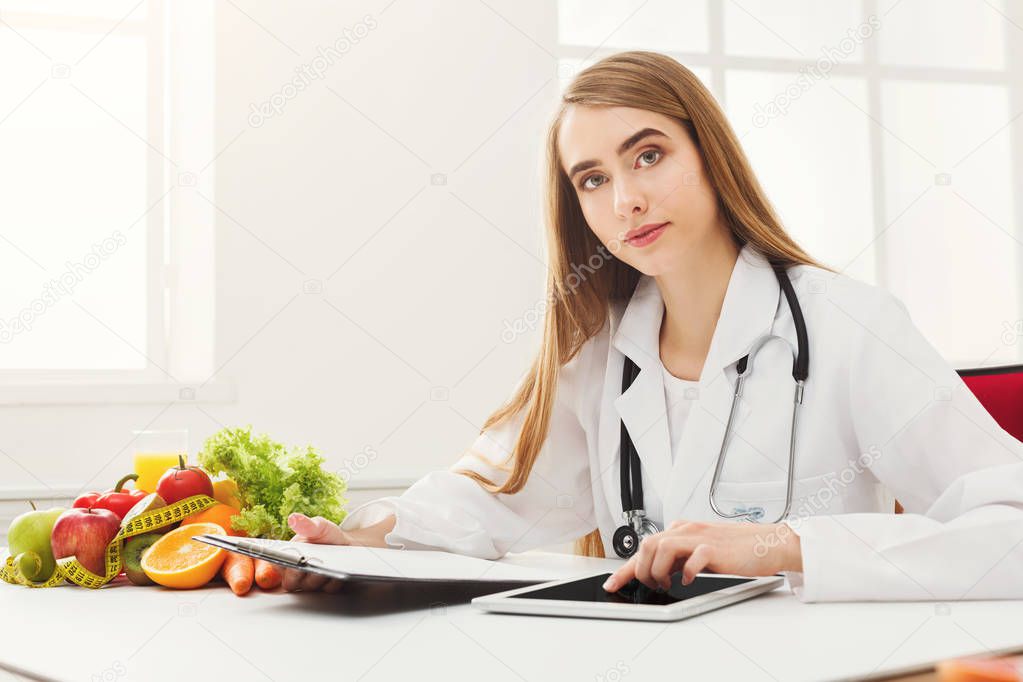 Female nutritionist working on digital tablet