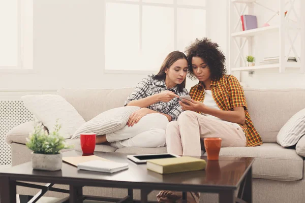 Amigos femeninos usando smartphone en casa — Foto de Stock