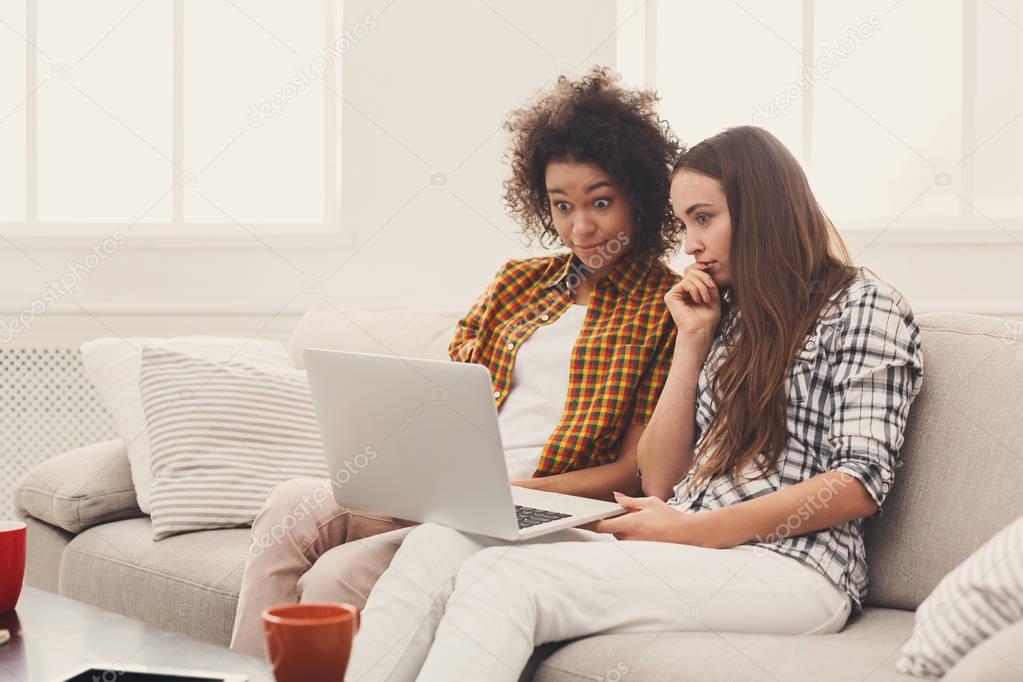 Two beautiful women using laptop at home