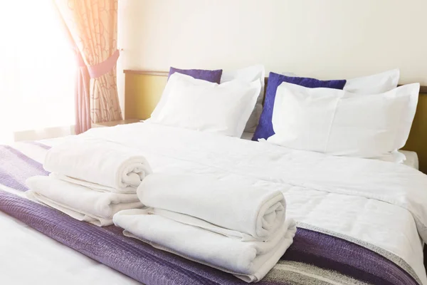 Toallas blancas en la cama en el dormitorio del hotel —  Fotos de Stock