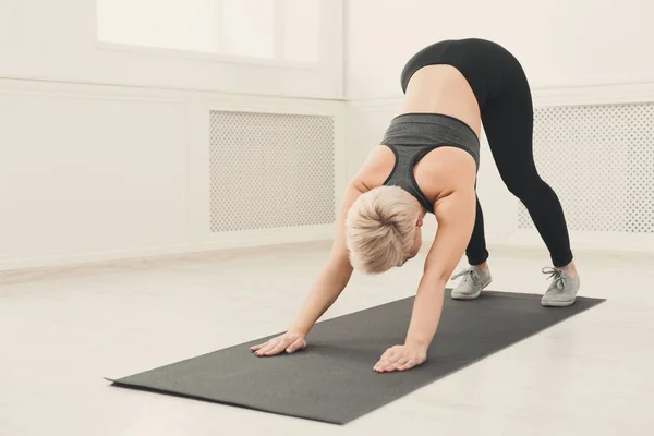 Yoga uitrekken. Vrouw in hond pose — Stockfoto