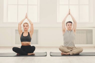 Genç çift padmasana içinde oturan yoga uygulamak