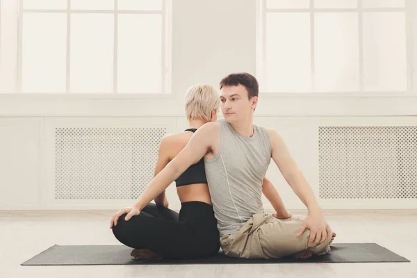 Unga par praktisera yoga tillsammans i studion — Stockfoto
