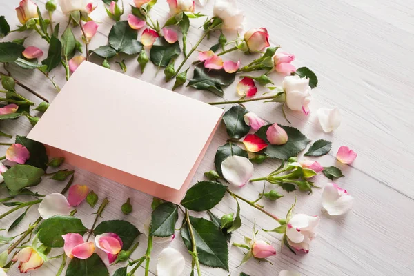 Tarjeta de papel hecha a mano en rosa marco de rosas naturales en madera rústica blanca —  Fotos de Stock