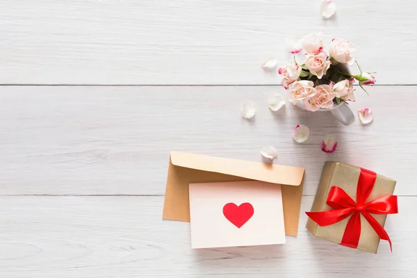 Rose różowy tło valentine kwiaty bukiet płatki, pudełeczka, ręcznie kartkę z życzeniami z sercami na biały rustykalnym drewna — Zdjęcie stockowe