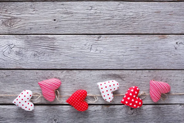 Fondo de San Valentín, corazones de almohada bordean la madera — Foto de Stock