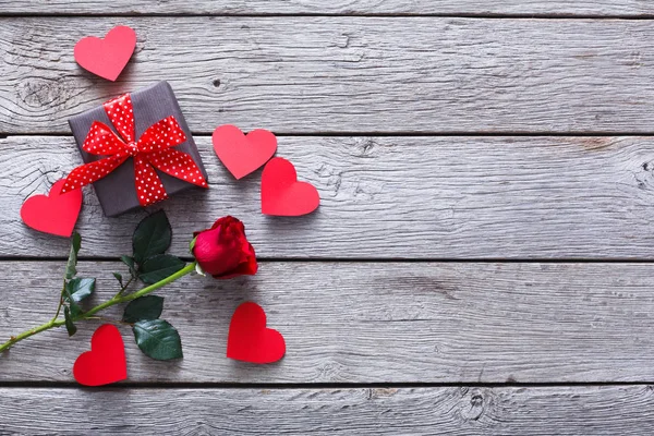 Valentinshintergrund, handgemachte Herzen, Rose und Geschenk auf Holz — Stockfoto