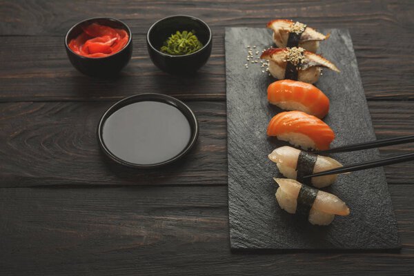 Set of sushi on black wood background, closeup