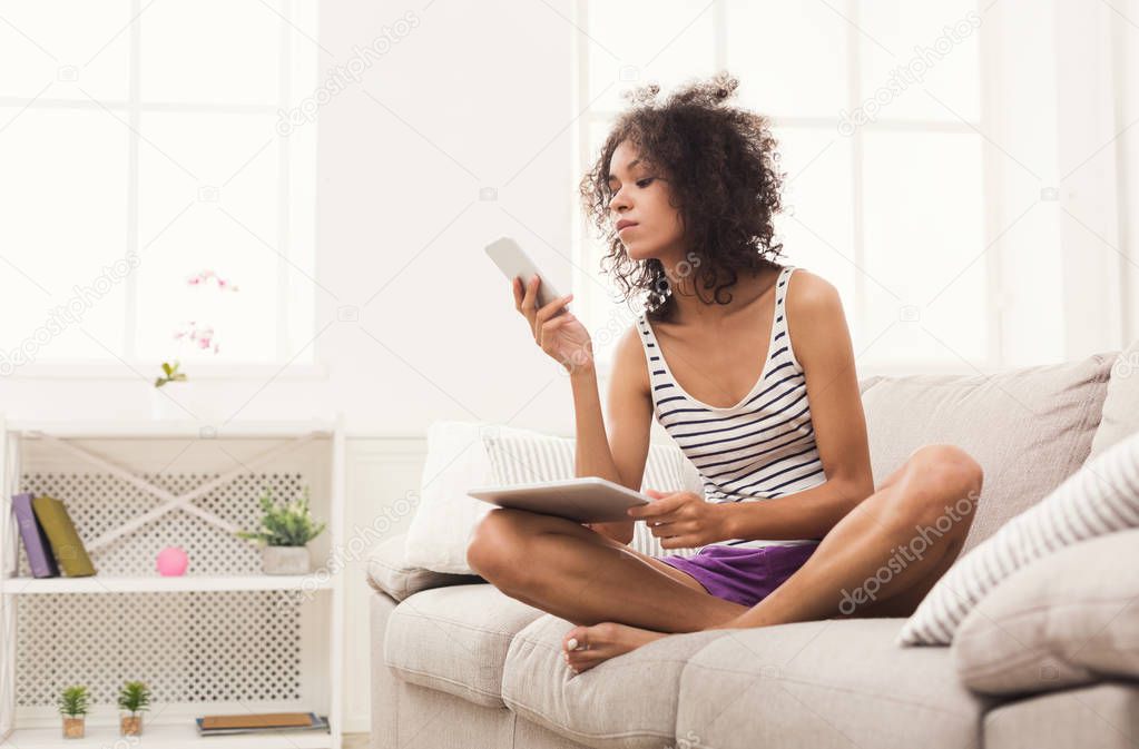 Young girl with laptop messaging on mobile