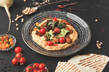 Humus sebze ve siyah arka plan üzerine deniz ürünleri ile