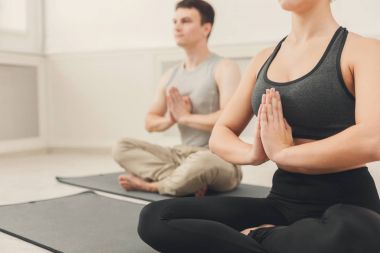 Genç çift padmasana içinde oturan yoga uygulamak