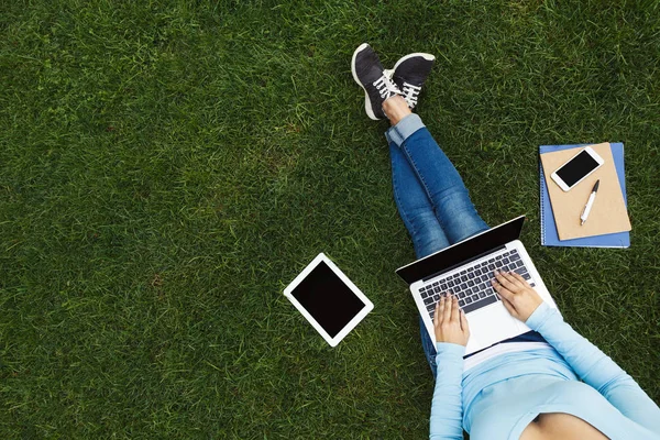 Dívka s notebookem na trávě — Stock fotografie