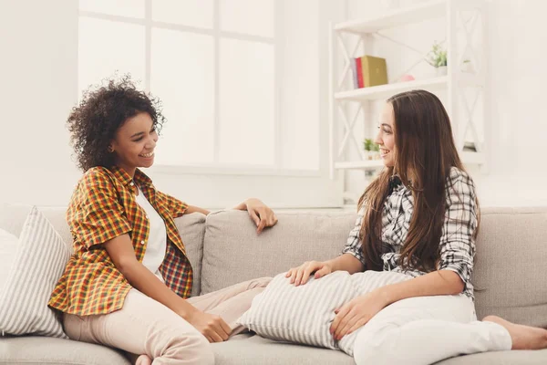 Twee jonge vrouwelijke vrienden thuis in gesprek — Stockfoto