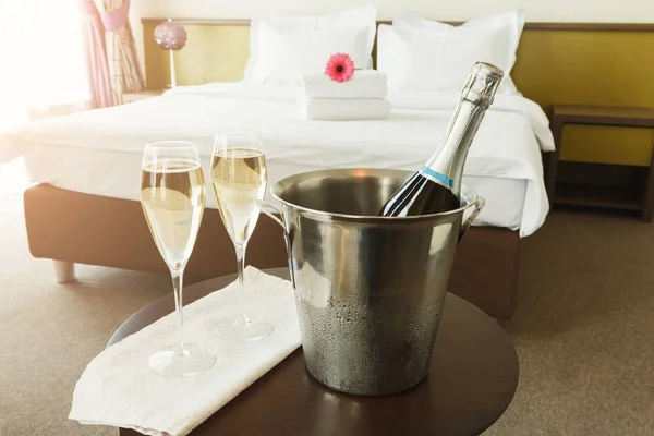 Dois copos e garrafa de champanhe no hotel — Fotografia de Stock