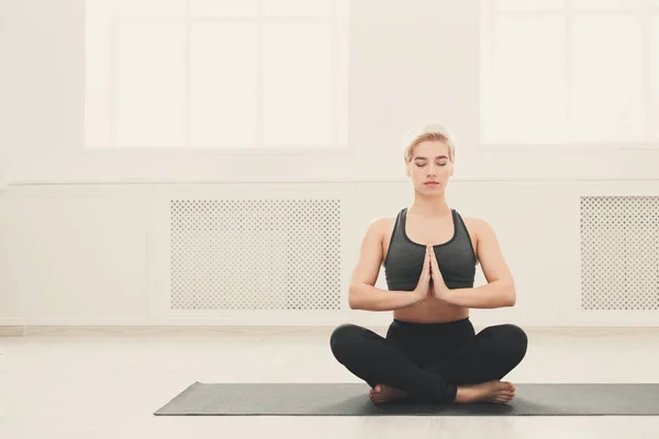 Junge Frau praktiziert Yoga sitzend in Padmasana — Stockfoto