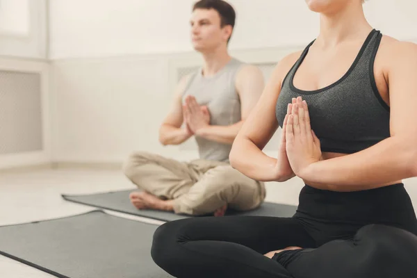 Pareja joven practicando yoga sentada en padmasana — Foto de Stock