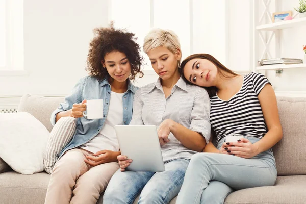 Drei glückliche Freundinnen mit Tablette und Kaffee trinken — Stockfoto