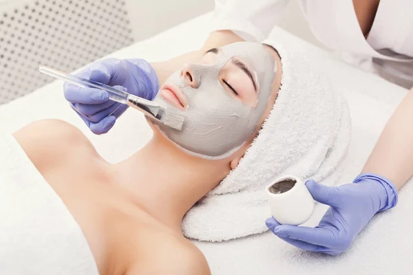 Mujer consigue máscara facial por esteticista en el spa —  Fotos de Stock